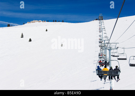 Gli sciatori trasportati su una seggiovia per il retro bocce di Vail ski resort, Vail, Colorado, Stati Uniti d'America, America del Nord Foto Stock