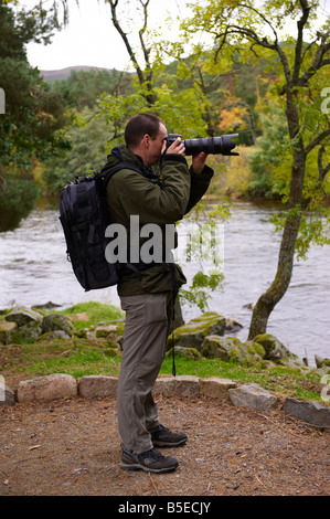 Fotografo utilizzando un D300 con Nikon 70-200mm VR lente fuori dal fiume di Scozia UK Foto Stock