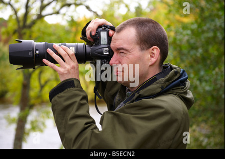 Fotografo utilizzando un D300 con Nikon 70-200mm VR lente fuori dal fiume di Scozia UK Foto Stock