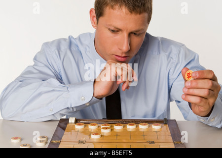 Imprenditore cinese a giocare a scacchi Foto Stock