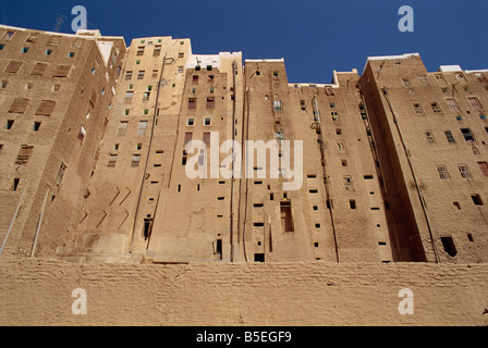 Spalle del fango alte case di mattoni che mostra i fori nella parete per bagni, la città murata di Shibam, Wadi Hadramaut, Yemen Foto Stock