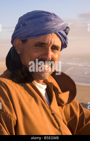 Abdullah, il giro sul cammello uomo su Tamraght beach, Marocco Foto Stock