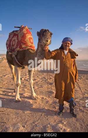 Abdullah, il giro sul cammello uomo su Tamraght beach, Marocco Foto Stock