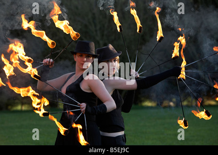 Femmina firepoise fire ballerini performance di artista indossare cappelli azienda ventilatori antincendio eseguendo Foto Stock