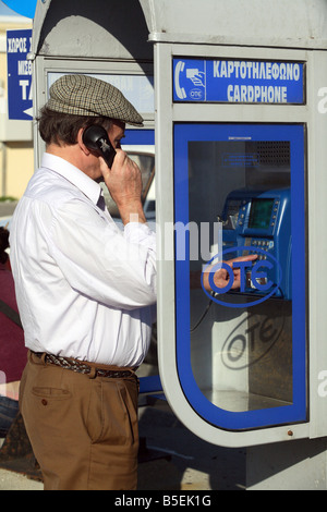 L uomo a un telefono pubblico stand in Rhodes, Grecia Foto Stock