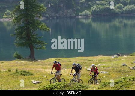 Tre piloti mountainbike guidando lungo il waterside Foto Stock