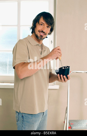 Giovane uomo con una spatola, sorridente, ritratto Foto Stock