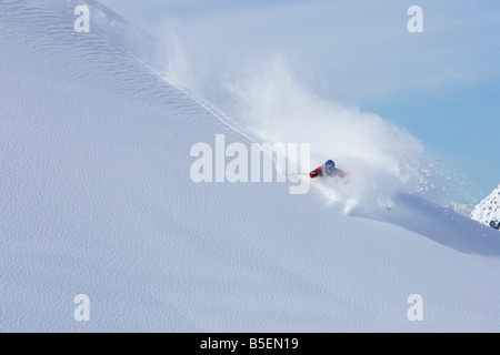 Sciatore facendo un giro stretto sulla neve intatta Foto Stock