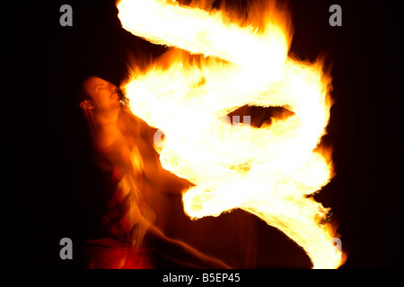 Firepoise uomo artista prestazioni di visualizzazione di modelli d'incendio con fune di fuoco giocando con il fuoco Foto Stock