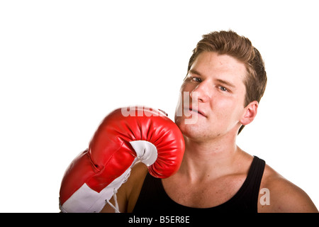 Un atletico cercando giovani man in black tank top rosso che indossa i guantoni con un guanto sul mento Foto Stock