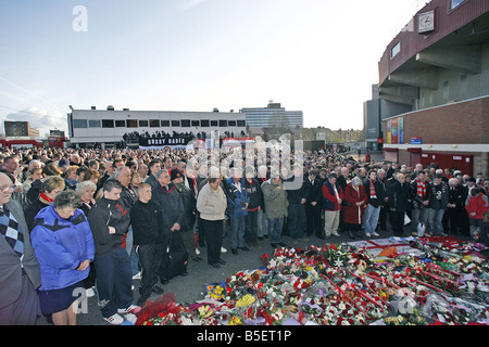 Tifosi si riuniscono al di fuori di Old Trafford per il monaco di baviera disastro aereo memorial cinquantesimo anniversario di fronte all'orologio fermo al momento del crash Foto Stock