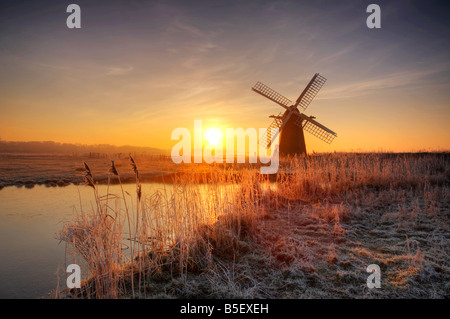 Il freddo trasformata per forte gradiente smerigliati sunrise al mulino a vento Herringfleet sul & Norfolk Broads Suffolk Foto Stock