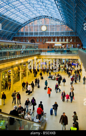 Londra , St Pancras stazione stazione ferroviaria , shopping arcade , piattaforma , causeway & blue travi di acciaio del tetto Foto Stock