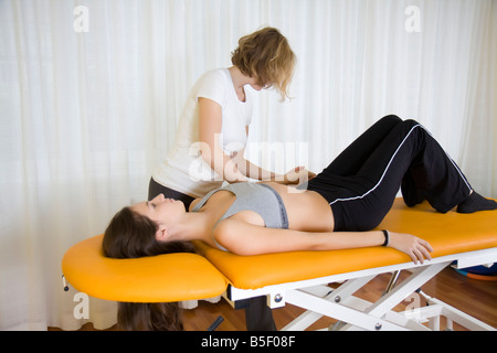 Fisio terapia: terapista rilassa le tensioni dei muscoli della spalla Foto Stock