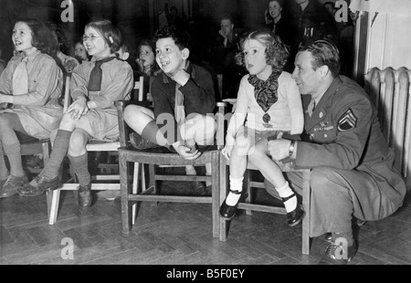 Noi soldati dell esercito celebrare la Great American Thanksgiving Day festival presso la Columbia Club di Londra per intrattenere i bambini dal lato est di un soldato guardando un topolino film con i bambini seduti su sedie di legno di novembre 1943 Foto Stock