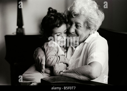 Bambino di due anni è abbracciato dalla sua grande nonna, Inghilterra 1982 Foto Stock