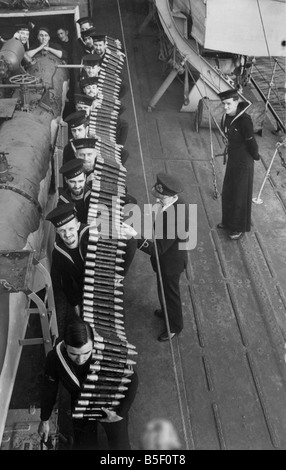 Pom-pom i gusci essendo passati alle piattaforme dal guscio camere dalla Royal Navy marinai nella Seconda Guerra Mondiale; Febbraio 1942 Foto Stock