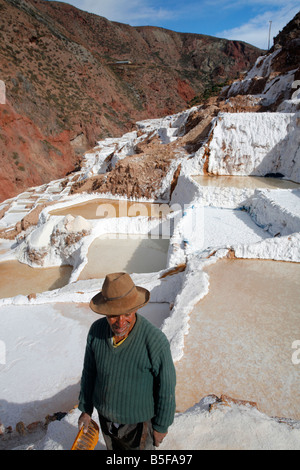 Il Salinas de Maras in Perù la Valle Sacra, con un lavoratore in primo piano. Foto Stock