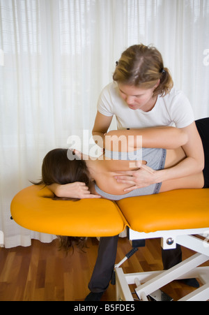 Fisio terapia: terapista rilassa le tensioni dei muscoli della schiena Foto Stock