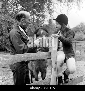 Sterling Moss (Ex Racing Driver). Visto qui con il cavallo e la figlia. Giugno 1974 S74-3861 Foto Stock