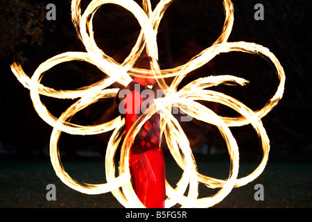 Firepoise uomo artista prestazioni di visualizzazione di modelli d'incendio con sfere di poi giocare con il fuoco Foto Stock