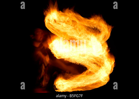 Firepoise uomo artista prestazioni di visualizzazione di modelli d'incendio con fune di fuoco giocando con il fuoco Foto Stock