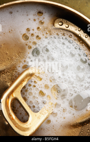 Aperto lattina di birra con la schiuma close up Foto Stock