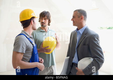 Conversazione tra due uomini di architetto al sito in costruzione Foto Stock