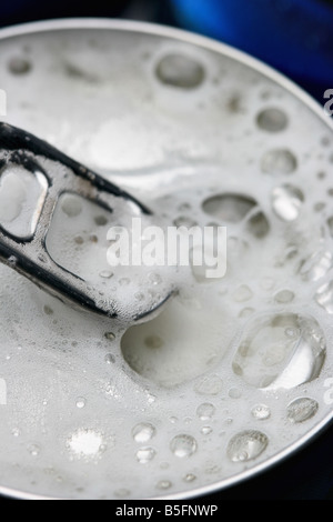 Aperto lattina di birra con la schiuma close up Foto Stock