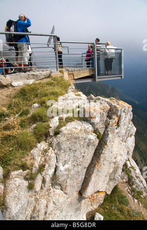 Visitatori stand su una piattaforma che si affaccia sul Picos de Europa a Fuente De Liebana Cantabria Spagna nord-occidentale Foto Stock