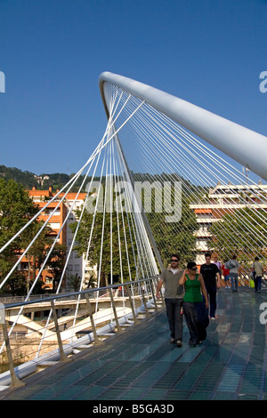 La gente camminare attraverso la passerella Zubizuri spanning del fiume Nervion di Bilbao Biscay Paesi baschi Spagna settentrionale Foto Stock