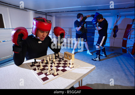 I concorrenti si affrontano in turni alternati in anello e sulla scheda in un nuovo sport noto come chess boxing Foto Stock