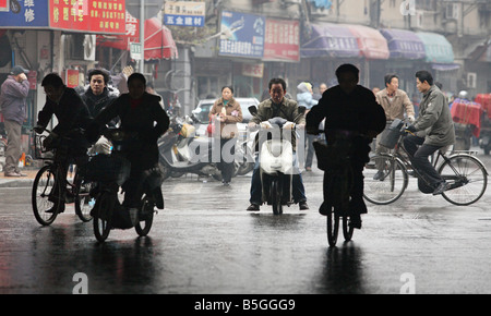 Persone su scooter e biciclette il canale di guida di Shanghai, Cina Foto Stock