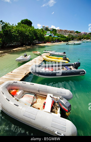 CRUZ BAY, Isole Vergini americane: Gommoni gonfiabili ormeggiati su un piccolo molo di legno nella Baia di Cruz, a St. John, nelle Isole Vergini americane. Il molo funge da comodo punto di attracco per piccole imbarcazioni, fornendo accesso alla città per i diportisti e i visitatori dell'isola. Foto Stock