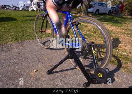 Racer il riscaldamento su una bicicletta trainer prima di iniziare una bicicletta da ciclocross gara Foto Stock