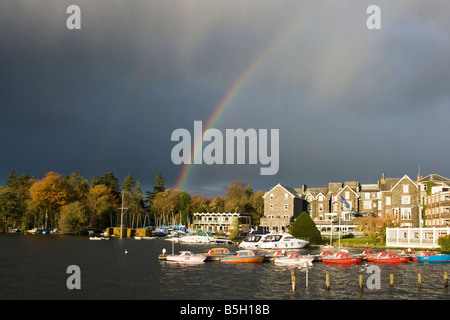 Le barche attraccate al Lago di Windermere con arcobaleno nel cielo nuvoloso. Foto Stock