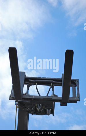 Carrello elevatore a forche in azione sul cielo blu sullo sfondo Foto Stock