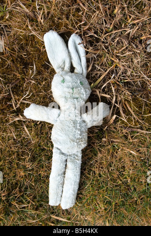 Bambino abbandonato s coniglio giocattolo posa su erba Abstract Foto Stock