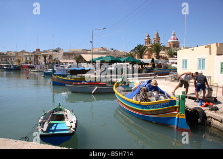 I pescatori maltesi lo scarico la loro barca nel porto di Marsaxlokk, Malta. Foto Stock