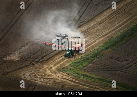 Fotografia aerea mostra una mietitrebbiatrice e il trattore funziona utilizzando la navigazione satellitare in una fiield vicino a Clare in Suffolk Foto Stock