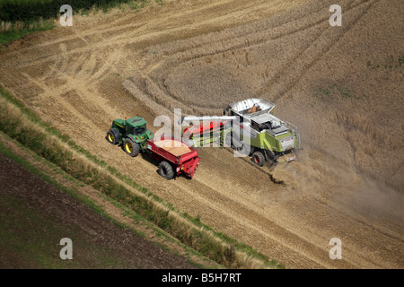 Fotografia aerea mostra una mietitrebbiatrice e il trattore funziona utilizzando la navigazione satellitare in una fiield vicino a Clare in Suffolk Foto Stock