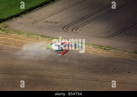 Fotografia aerea mostra una mietitrebbiatrice e il trattore funziona utilizzando la navigazione satellitare in una fiield vicino a Clare in Suffolk Foto Stock