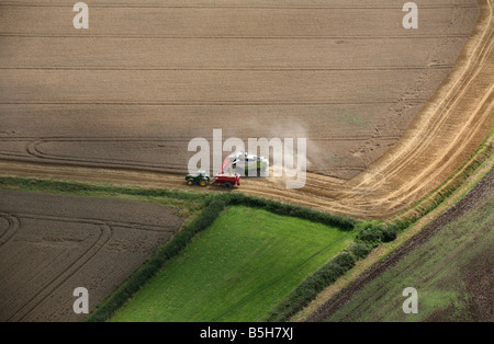 Fotografia aerea mostra una mietitrebbiatrice e il trattore funziona utilizzando la navigazione satellitare in una fiield vicino a Clare in Suffolk Foto Stock