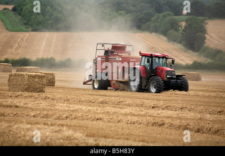 Un trattore rende il fieno bails tra Clare e Cavendish in Suffolk Foto Stock