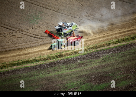 Fotografia aerea mostra una mietitrebbiatrice e il trattore funziona utilizzando la navigazione satellitare in una fiield vicino a Clare in Suffolk Foto Stock