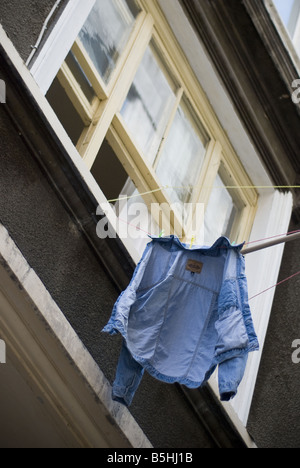 Una camicia che è appesa ad asciugare al di fuori di un appartamento nella finestra Curkuma in Turchia, Istanbul. Foto Stock