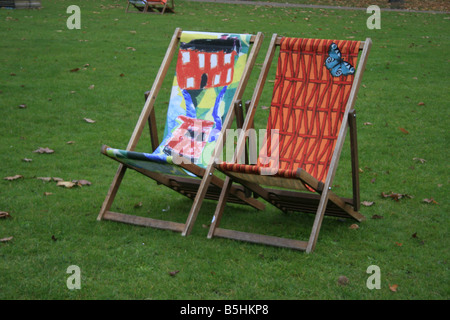 Due vuoti sdraio colorate in St James Park London Foto Stock