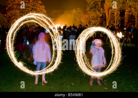 Due bambini di giocare con le botti sulla notte dei falò, Northwich, Cheshire, Inghilterra, Regno Unito Foto Stock