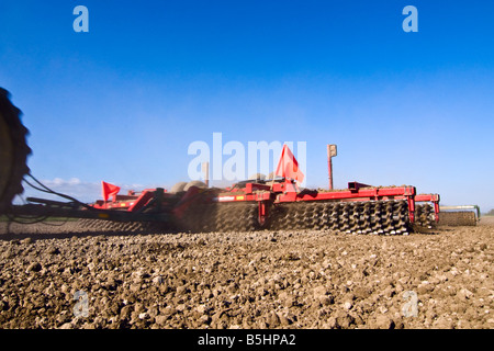 Un trattore tirando una trinciatrice e rotolamento harrow Preparare un seedbed per patate in primavera in Northwest Washington Foto Stock