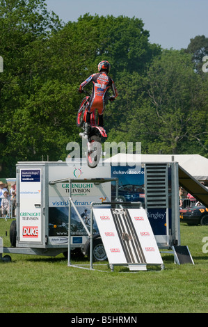 Motociclista acrobatico sulla sua moto saltando su una roulotte eseguono acrobazie Cowpie Rally Betchworth Surrey Foto Stock